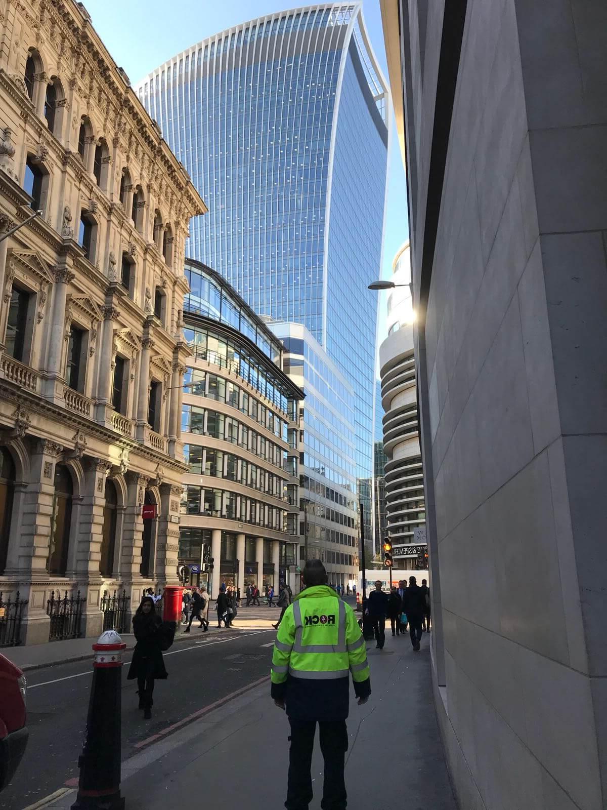 Rock Power Connections的一名员工穿着一件夹克，抬头看着伦敦的一座摩天大楼